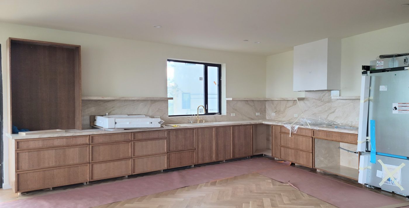 Kitchen during build with timber cabinetry and marble